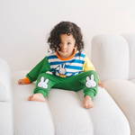 Child wearing the Miffy on the Move bamboo lounge set with bicycle sweatshirt and green joggers